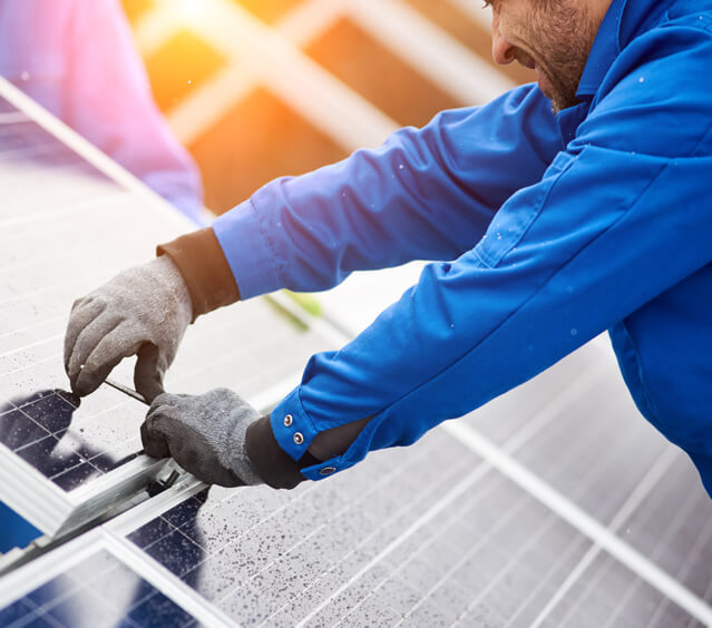 Installateur an einer Photovoltaik-Platte Installateur an einer Photovoltaik-Platte